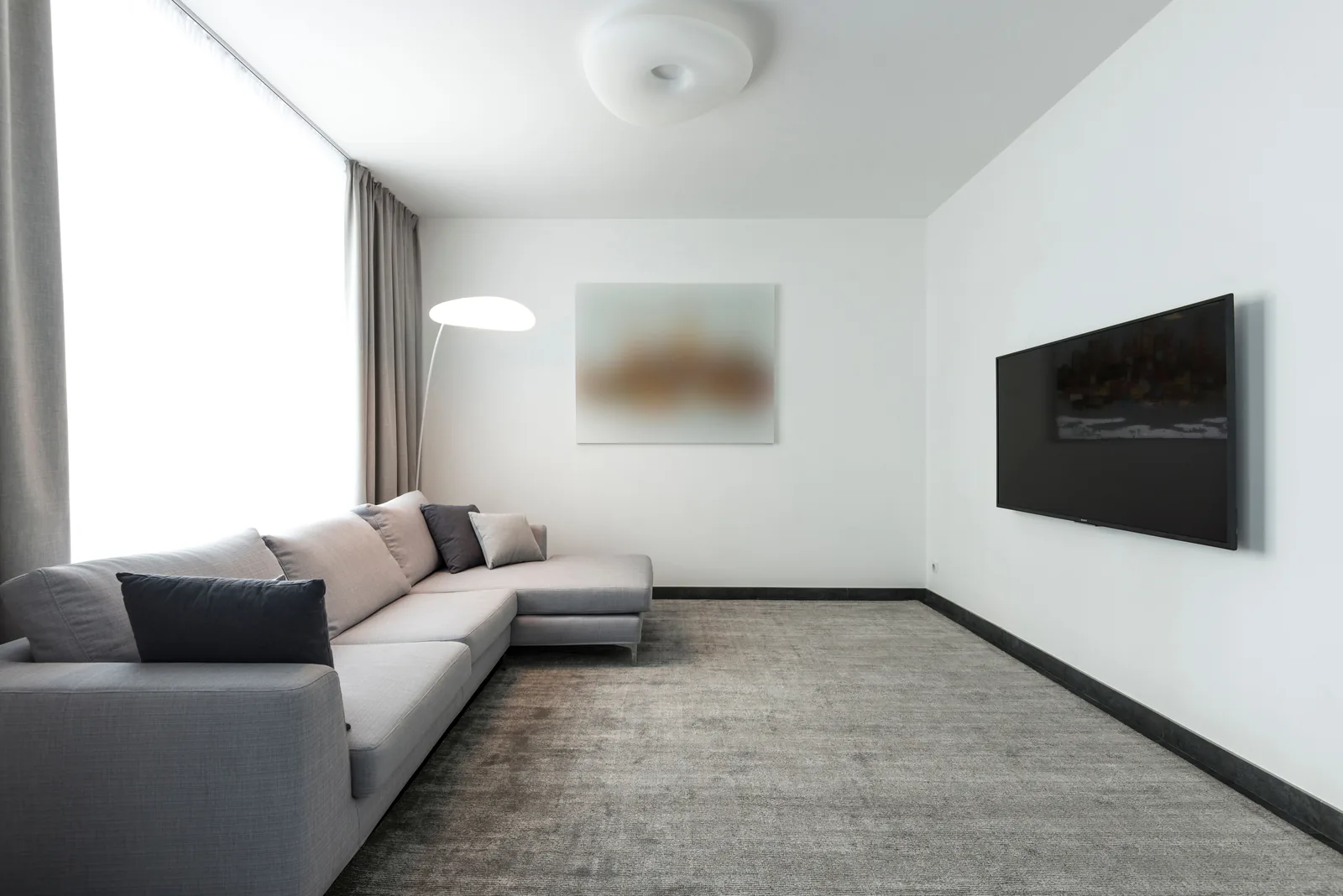 Light grey wall-to-wall carpet in a modern living room with a grey sectional sofa