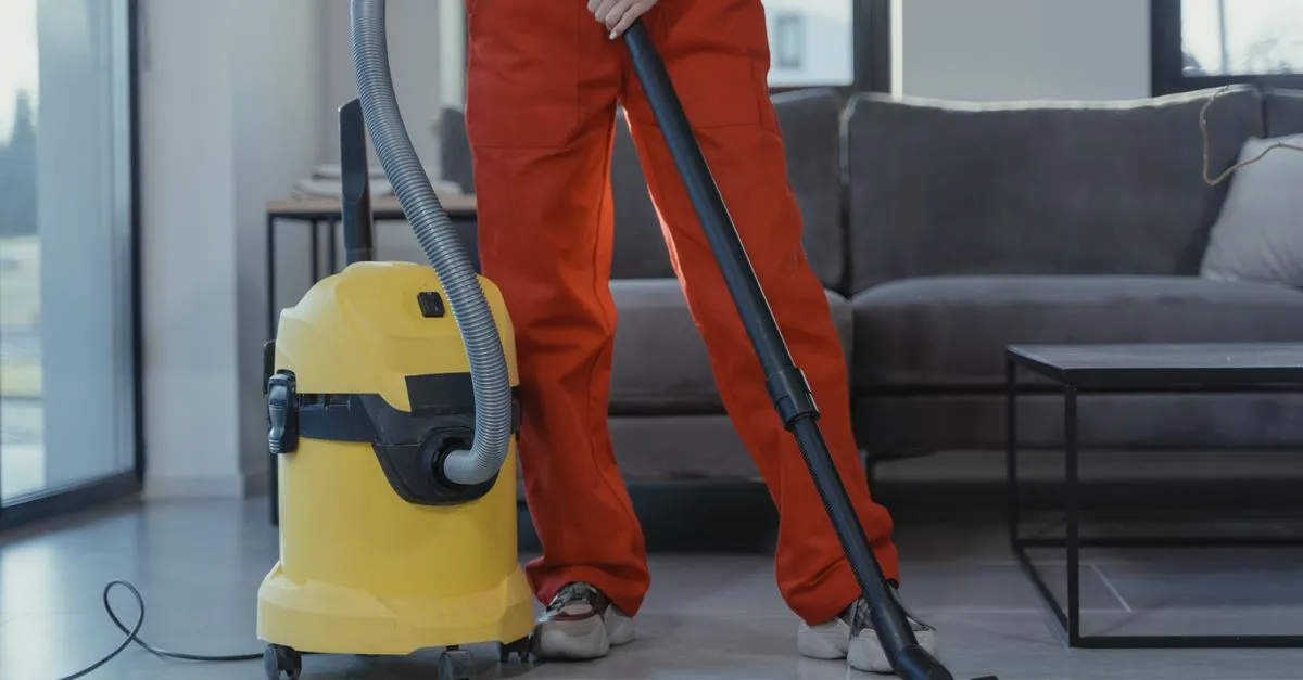 Professional carpet cleaner vacuuming a living room carpet in a Ballarat home